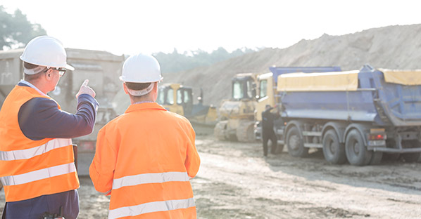 Two men discussing an earthmoving operation on jobsite