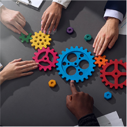 B2B marketing employees moving colorful gears on conference table